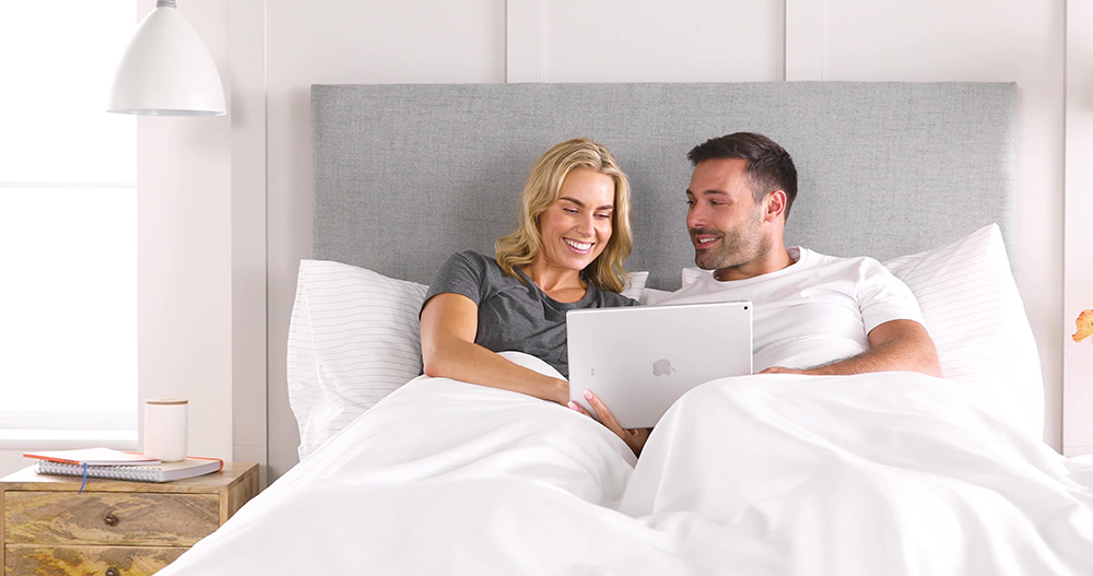 couple in bed with laptop